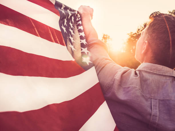 istock Handsome, young man waving an American flag 1150340942