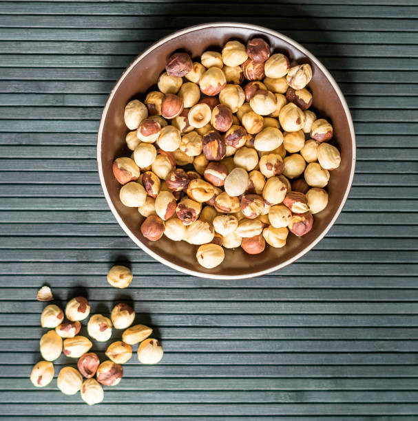 istock Healthy food  for background image close up hazelnuts.  Nuts texture on top view on the cup plate 1150341175