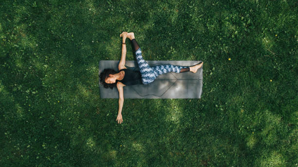 frau macht yoga im park - naturreservat stock-fotos und bilder