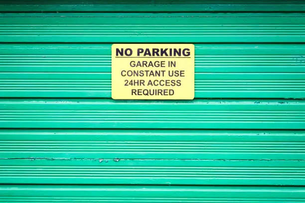 No parking sign on green roller shutter door uk