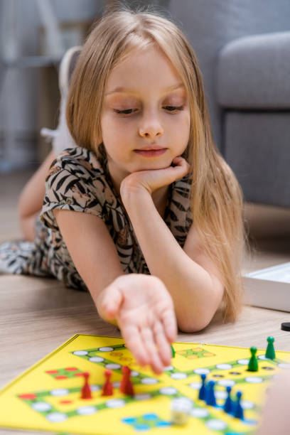 istock Little girl playing board game at home 1150343647