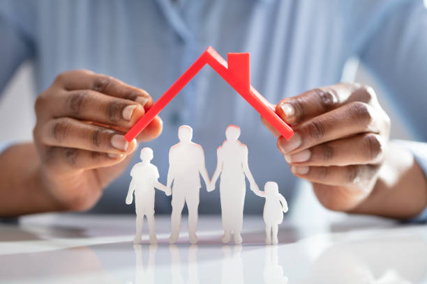 istock Person Protecting Family Figures With Roof 1150345397