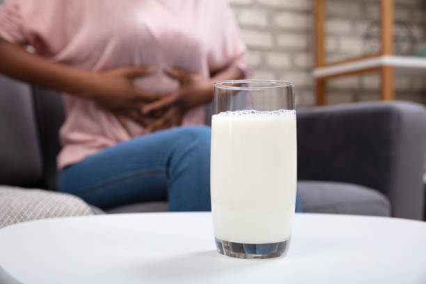 Glass Of Milk In Front Of Woman Having Stomach Pain Woman Suffering From Stomach Pain With Glass Of Milk On White Desk lactose fermentation stock pictures, royalty-free photos & images