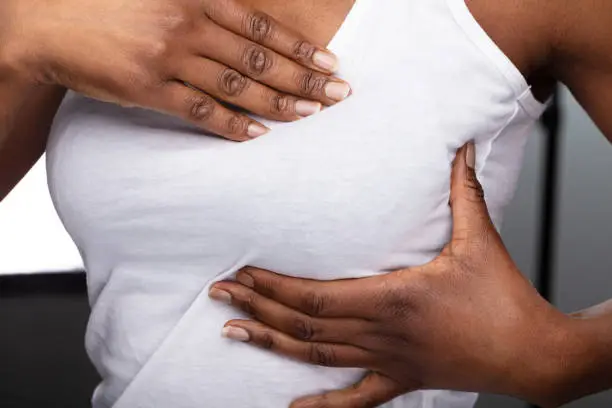 Close-up Of A Woman's Hand On Breast Showing Cancer Symptom