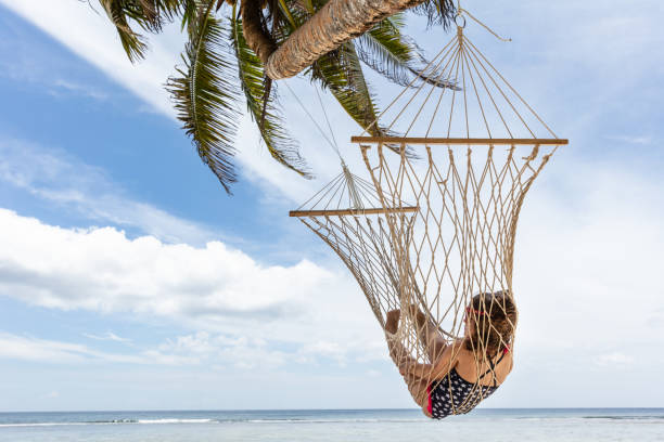 istock Girl Lying On Hammock Hanging On Palm Tree At Beach 1150346333