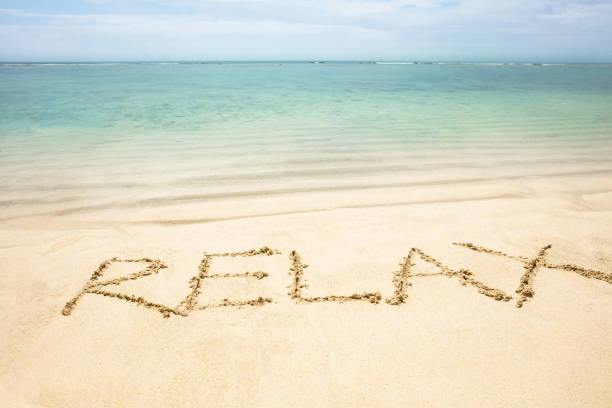 Relax Word Written On The Sand Near The Coastline At Idyllic Beach