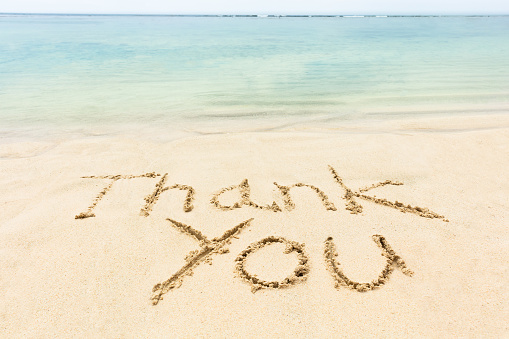 Thank You Word Written On The Sand Near The Coastline At Idyllic Beach