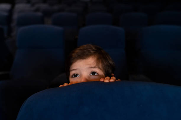 istock Scared boy watching a movie at the cinema 1150346636