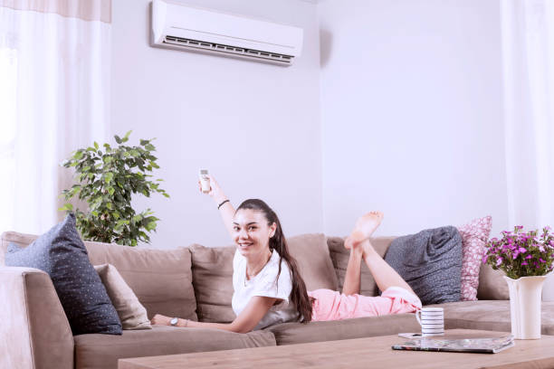 istock woman using remote control of air conditioner 1150347073