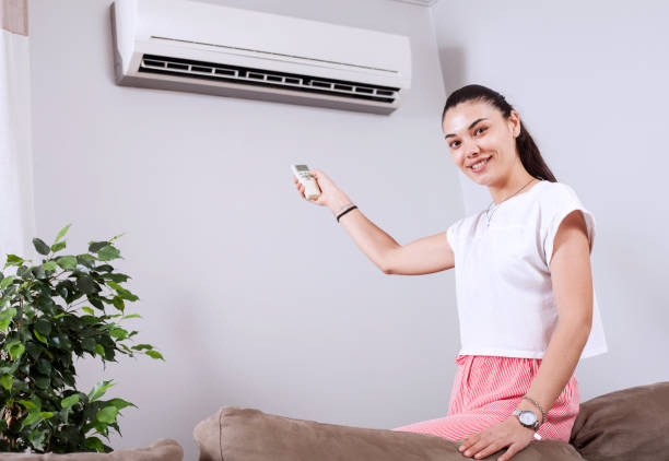 istock woman using remote control of air conditioner 1150347790