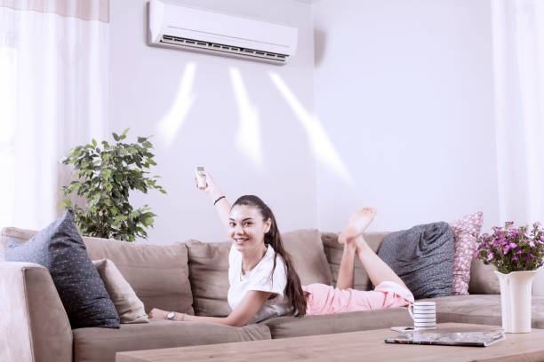 istock woman using remote control of air conditioner 1150351504
