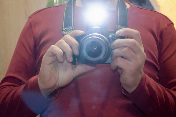 a man takes a selfie with a mirror camera with a flash in the mirror