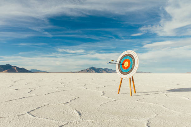 Arrows in Bulls-Eye of the Target Arrows are in the center of the target, hitting their mark in the bulls-eye. Precision is paramount in target shooting. This image symbolizes preparation, determination and accuracy it takes to reach a goal. Image taken on the salt flats of Utah, USA. target shooting photos stock pictures, royalty-free photos & images