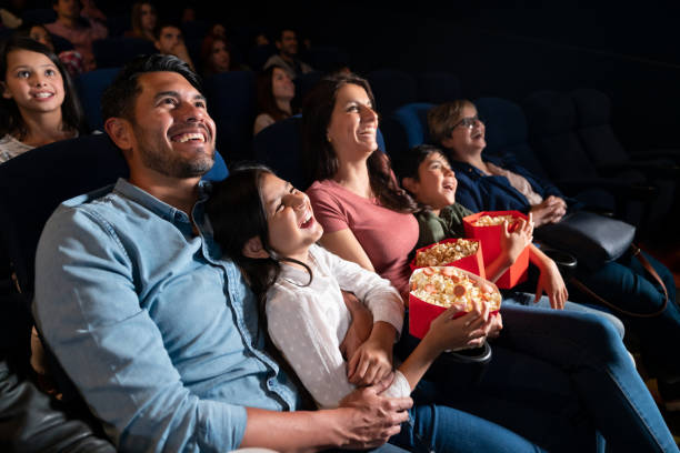 familia feliz viendo una película de comedia en el cine - sala de cine fotos fotografías e imágenes de stock