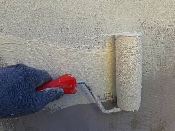 istock Wall painting with a roller. White-yellow paint 1150359084