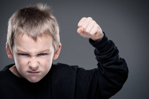 Loads of aggression in a little boy Loads of aggression in a little boy - education concept hinting behavioral problems in young children (shallow DOF) - little boy with hands clenched into fists about to punch someone cruel stock pictures, royalty-free photos & images