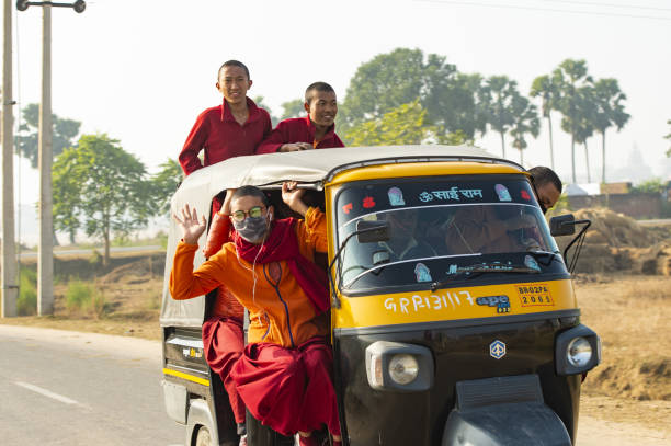 um grupo de monges budistas está em um auto rickshaw (tuc tuc) em bodh gaya. bodh gaya é um local religioso da índia, no estado indiano de bihar. - accident taxi driving tourist - fotografias e filmes do acervo