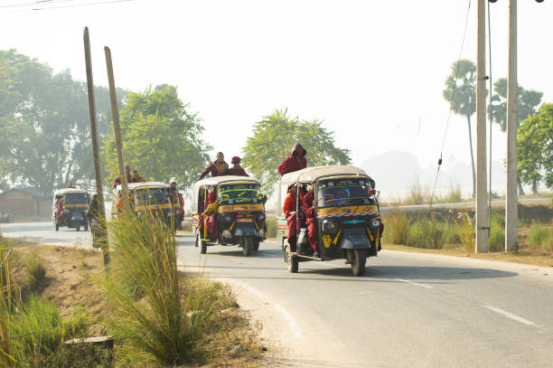 um grupo de monges budistas está em um auto rickshaw (tuc tuc) em bodh gaya. bodh gaya é um local religioso da índia, no estado indiano de bihar. - accident taxi driving tourist - fotografias e filmes do acervo