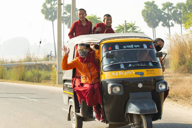 grupa buddyjskich mnichów jest na rikszy samochodowej (tuc tuc) w bodh gaya. bodh gaya – indyjski stan bihar. - accident taxi driving tourist zdjęcia i obrazy z banku zdjęć