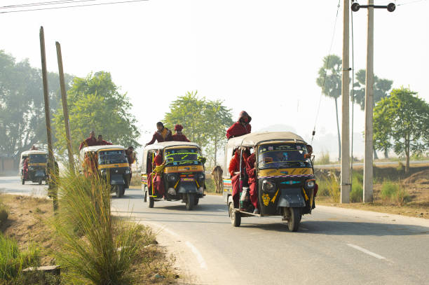 um grupo de monges budistas está em um auto rickshaw (tuc tuc) em bodh gaya. bodh gaya é um local religioso da índia, no estado indiano de bihar. - accident taxi driving tourist - fotografias e filmes do acervo