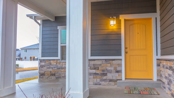 Panorama Entryway of a home with stairs going up to the front porch and door Panorama Entryway of a home with stairs going up to the front porch and door. Rectangular pillars, stone brick wall, and horizontal siding defines the facade of this home. front stoop photos stock pictures, royalty-free photos & images