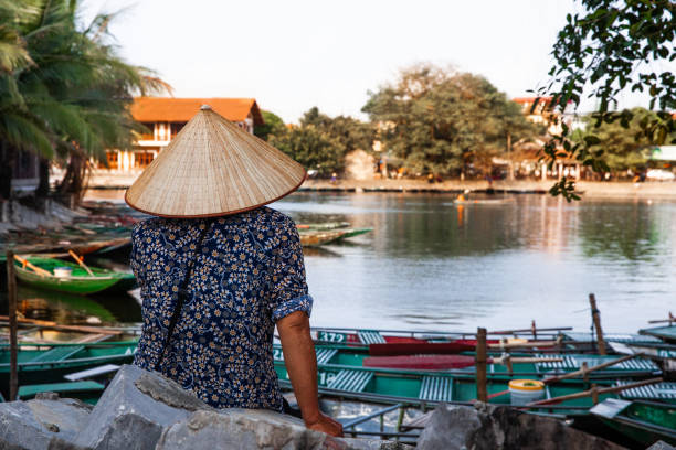 istock Vietnamese woman rowing a boat in river 1150372833
