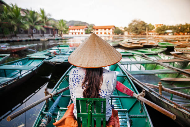 istock Vietnamese woman rowing a boat in river 1150374507