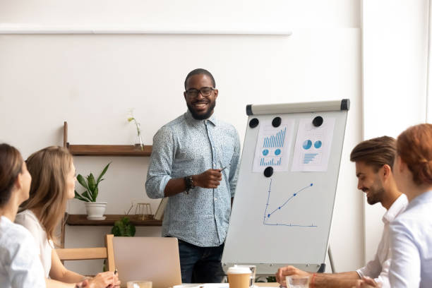 istock Smiling african conference speaker give flipchart presentation at office seminar 1150384622