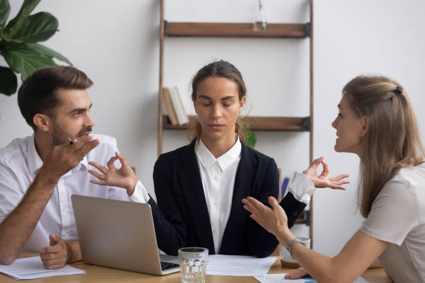 istock Stressed worker meditating at workplace ignoring arguing colleagues at meeting 1150384647