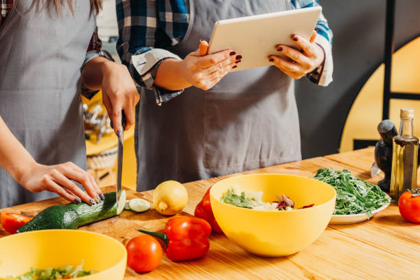 istock online recipe tablet women chopping veggies salad 1150384875
