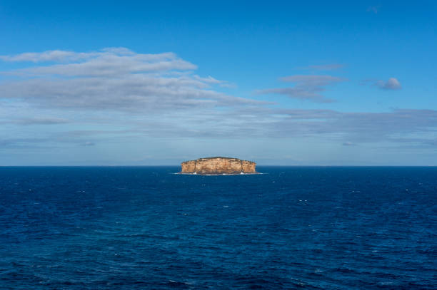 istock Isolated lonely island surrounded with deep blue ocean 1150385192