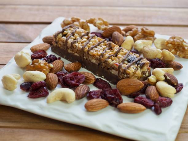 barra de chocolate y nueces, almendras, nueces, frambuesas - protein bar cereal oat cranberry fotografías e imágenes de stock