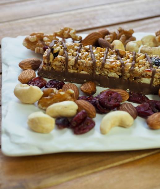 barra de chocolate y nueces, almendras, nueces, frambuesas - protein bar cereal oat cranberry fotografías e imágenes de stock