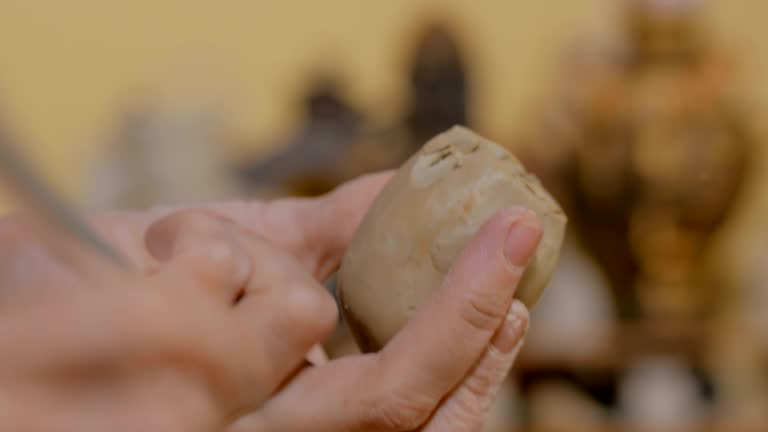 Woman potter making ceramic souvenir penny whistle in pottery workshop