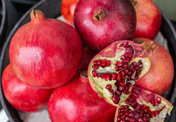 istock Delicious red pomegranates with shells and exposed seeds 1150392334