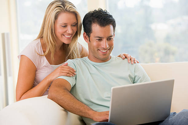 istock Couple in living room using laptop smiling 115039375