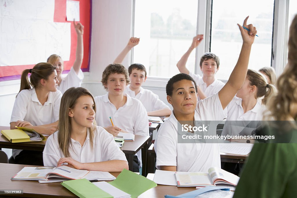 High school students contestar a una pregunta en clase - Foto de stock de Uniforme libre de derechos