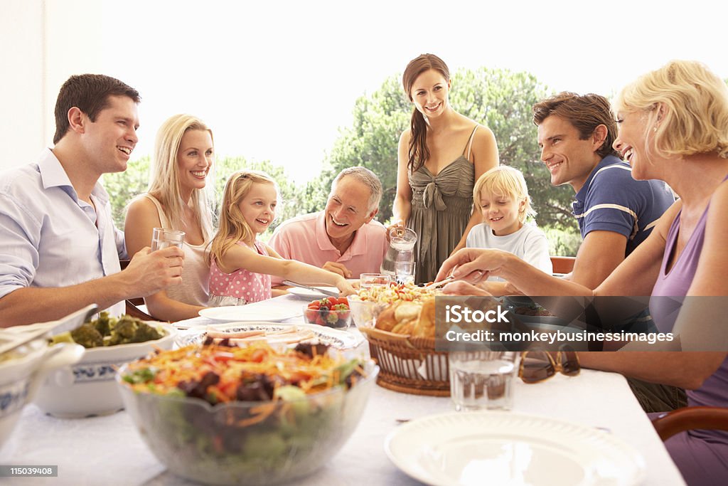 Extended family enjoying picnic Extended family enjoying picnic in garden Family Stock Photo