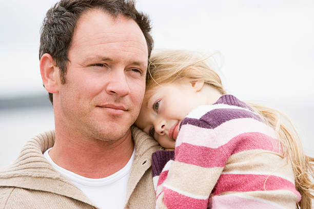 istock Father holding daughter at beach 115039411