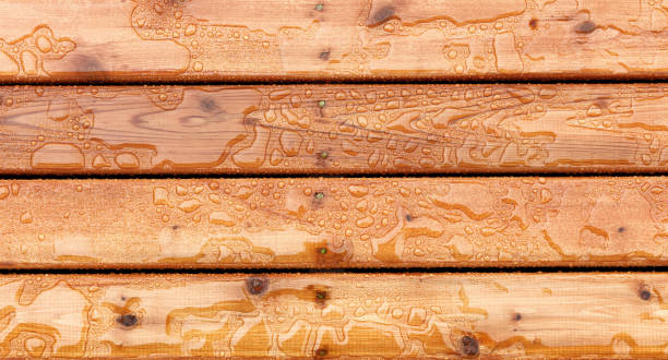 Top view of outdoor wooden stain deck boards with natural rain water on top of them stock photo