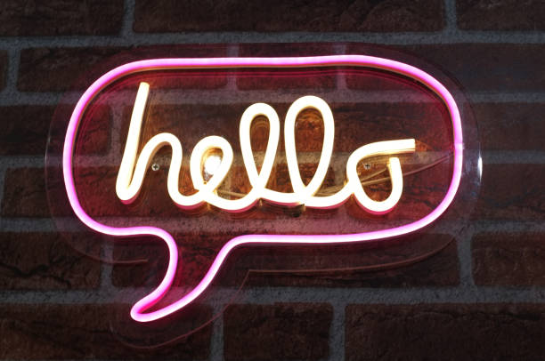 neon sign background saying " hello " sign hanging on a wall and lit brightly. - brightly lit imagens e fotografias de stock