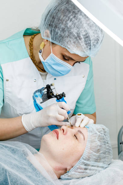 istock Permanent makeup, tattooing of eyebrows. Cosmetologist applying make up 1150402919