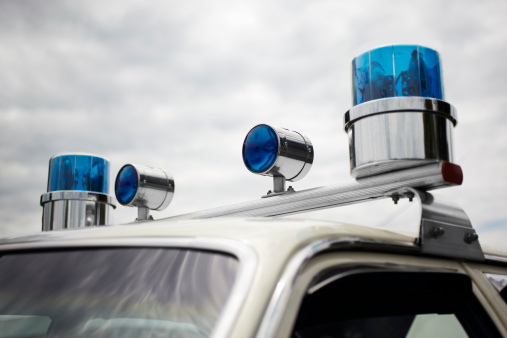 High resolution stock photo of older 1960's and 1970's style round blue police siren lights on a squad car.