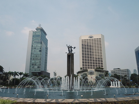 Jakarta, Indonesia - April 17, 2019: The Welcome Monument (Patung Selamat Datang) at Bundaran HI (Hotel Indonesia Roundabout) on Jalan Thamrin.