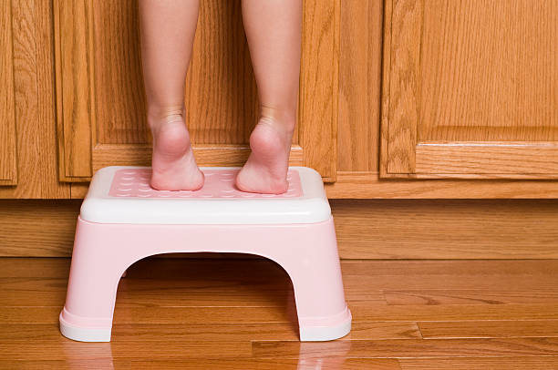 petite fille de pieds jambes debout tippy sur un tabouret marche-pied - escabeau photos et images de collection