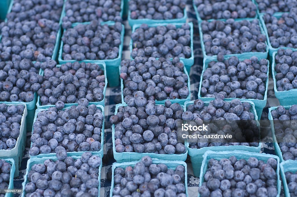 Groups of Blueberries in Multiple Small Baskets on a Table Blueberries in several baskets on a table.  Basket Stock Photo