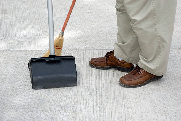 istock Maintenance Person Sweeping with Broom Into a Commercial Dustpan 115040746