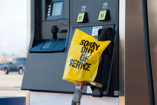 A modern gas station broken fuel pump with a Sorry  Out of Service sign and lock. 