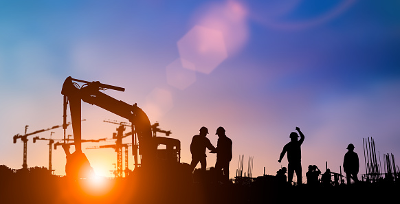 Silhouette of engineer and construction team working at site over blurred background for industry background with Light fair.Create from multiple reference images together