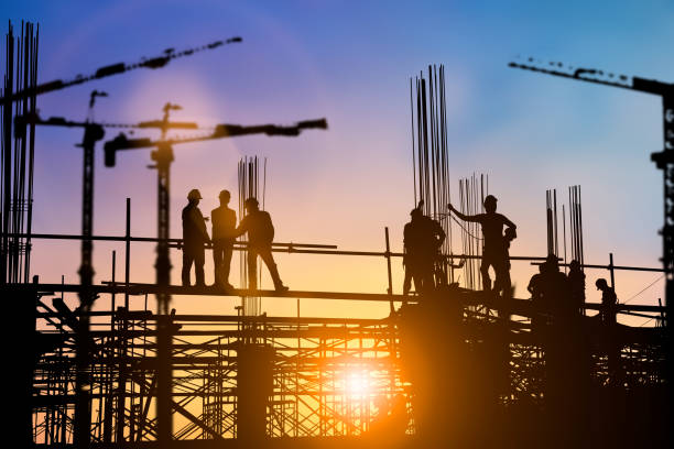 istock Silhouette of engineer and construction team working at site over blurred background for industry background with Light fair.Create from multiple reference images together 1150409553